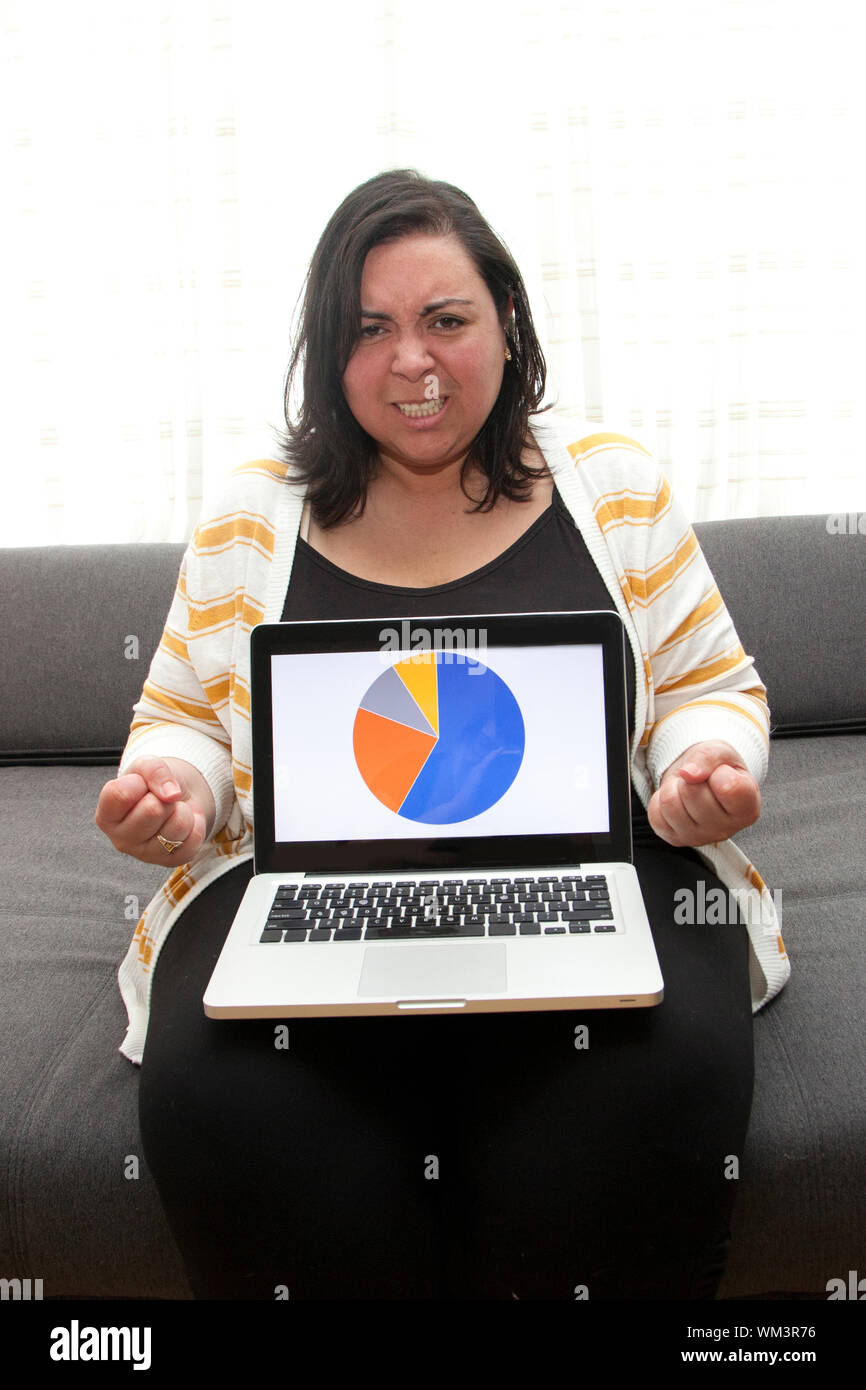 Femme fait une expression de colère et serre les poings à son ordinateur portable Banque D'Images