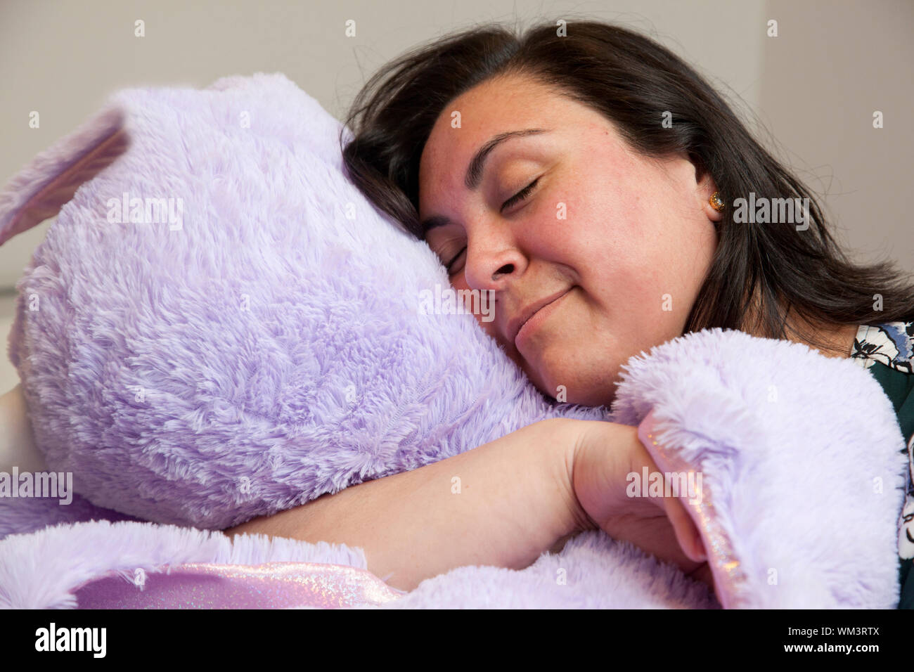 Femme adulte heureux avec son énorme peluche mauve est endormi ou au repos Banque D'Images