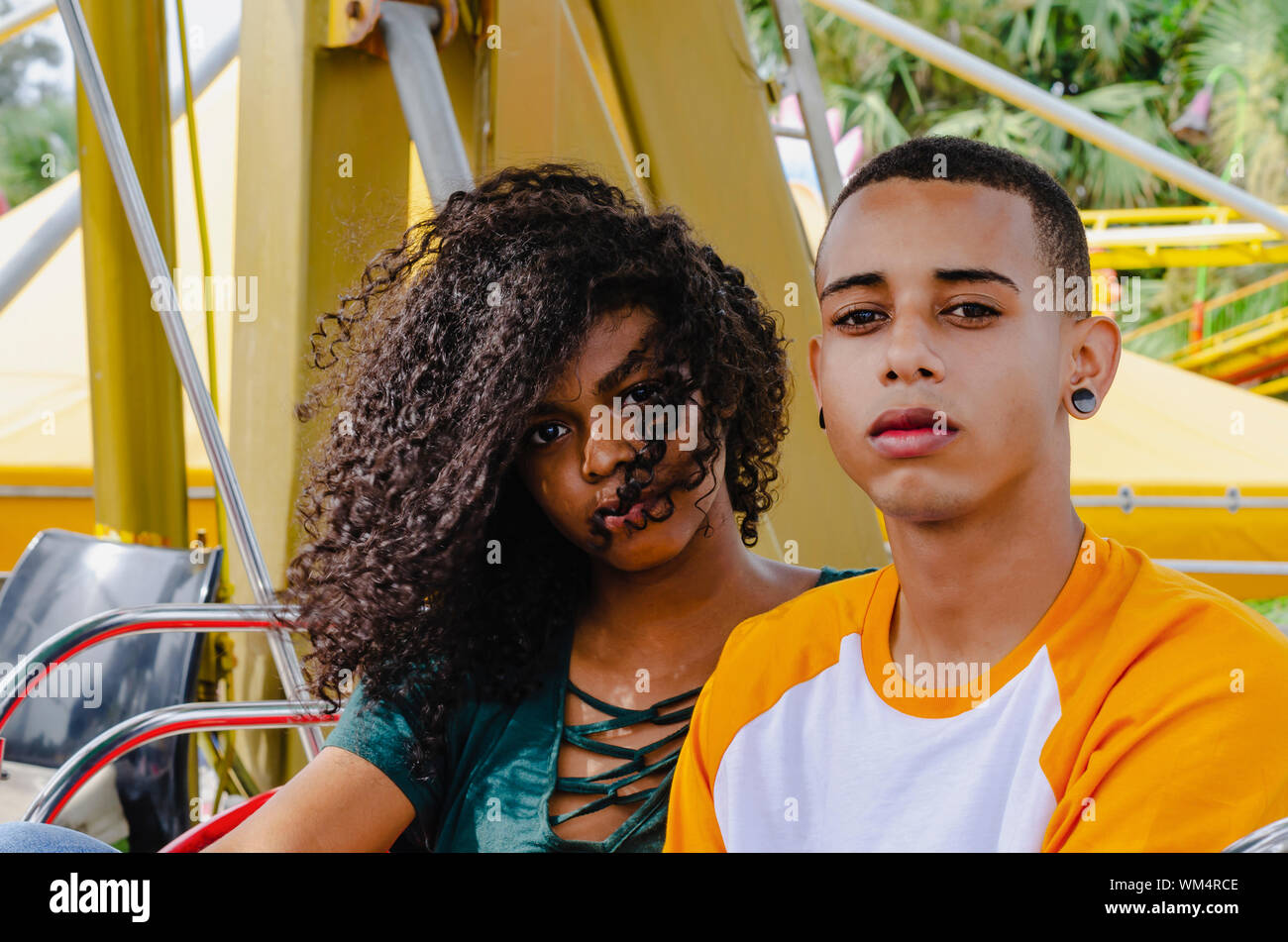 Jeune couple assis sur une grande roue looking at camera Banque D'Images