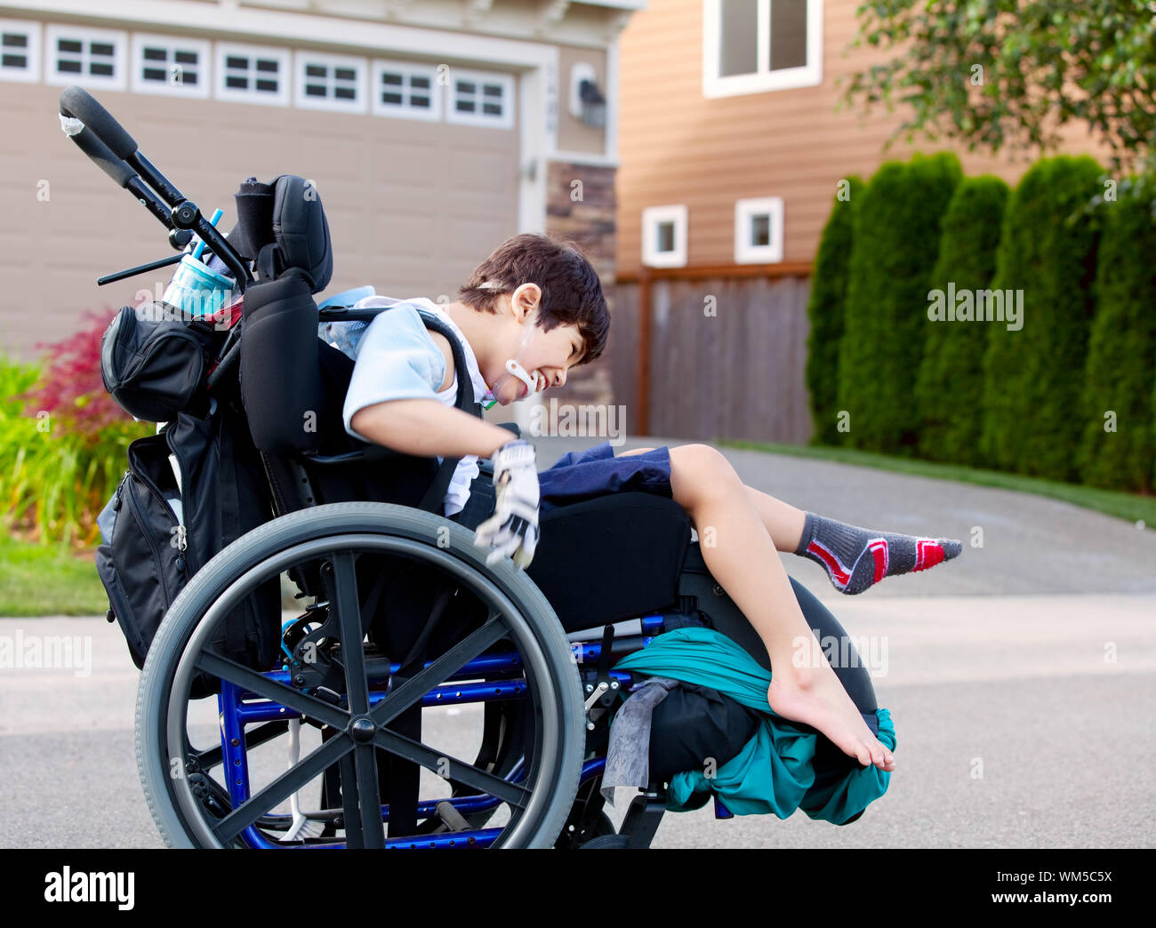 Happy little boy handicapés wheeling autour de l'extérieur en fauteuil  roulant Photo Stock - Alamy