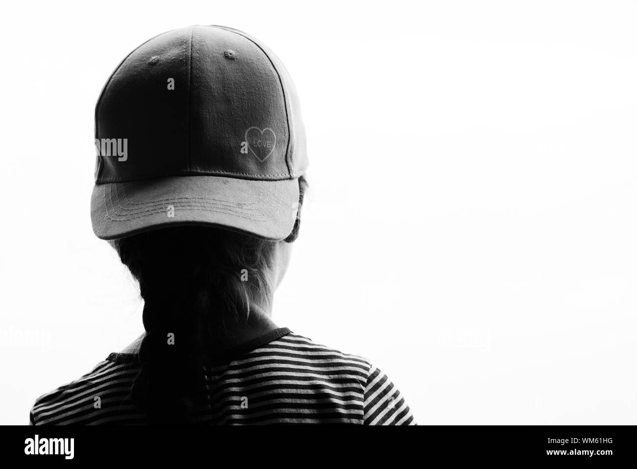 Jeune fille portant une casquette de baseball avec amour symbole de l'avant  vers l'arrière en silhouette en noir et blanc avec blanc copyspace salon  Photo Stock - Alamy