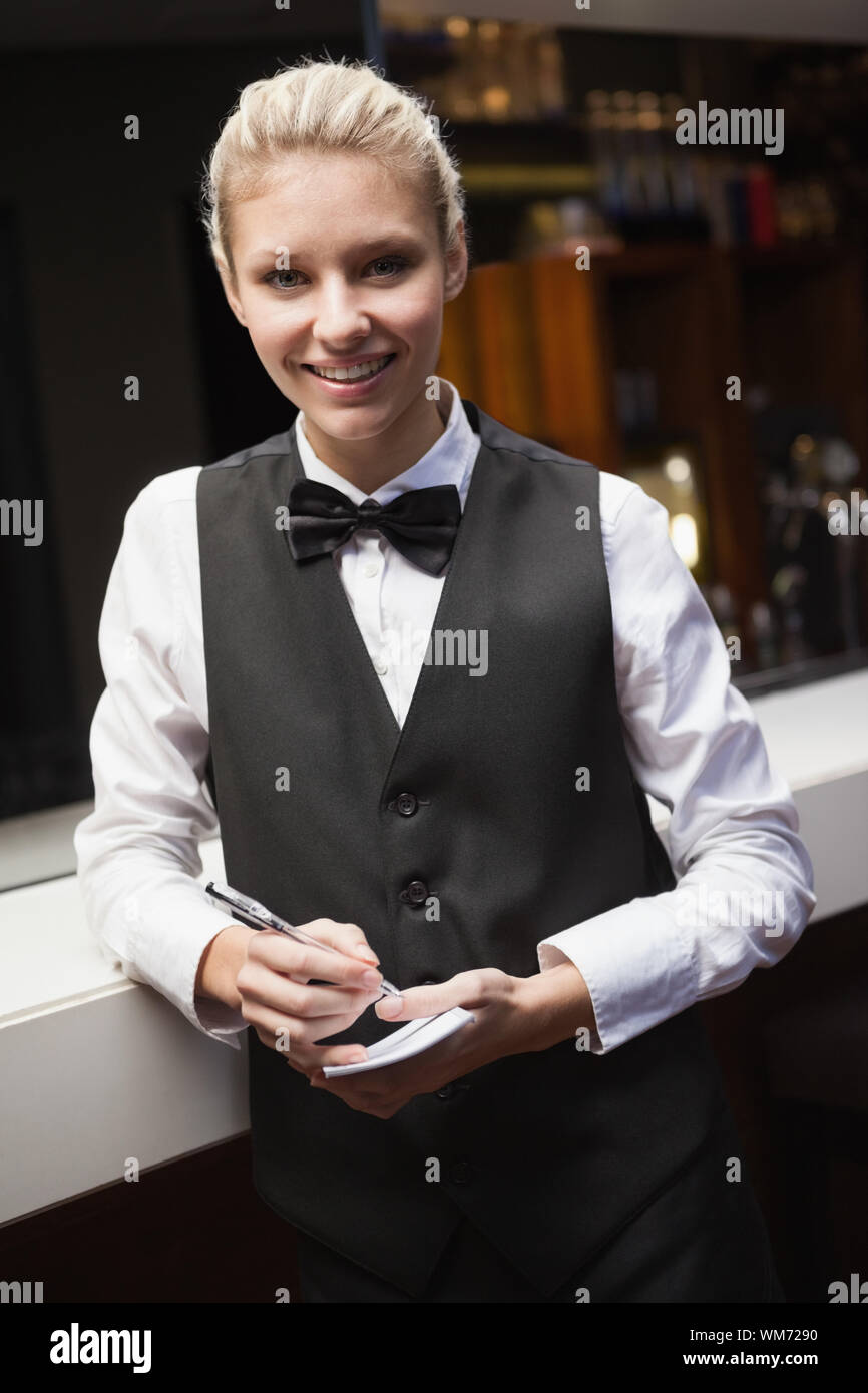 Jolie serveuse prendre une commande dans un bar Banque D'Images