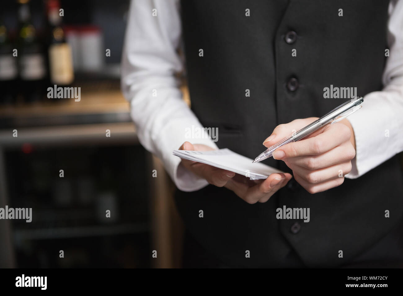 Jolie serveuse prendre une commande dans un bar Banque D'Images
