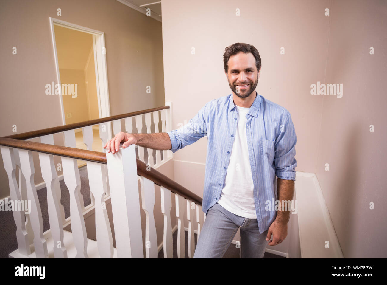 Casual man en montant les escaliers dans sa nouvelle maison Banque D'Images