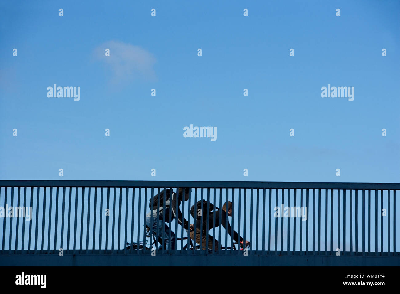 Les navetteurs cyclistes sur une balustrade de bridge Banque D'Images