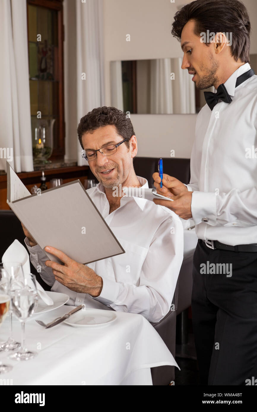 Waiter serving un couple dans un restaurant. Banque D'Images