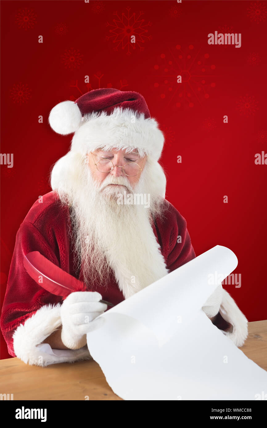 Santa écrit quelque chose avec une plume contre fond rouge Banque D'Images