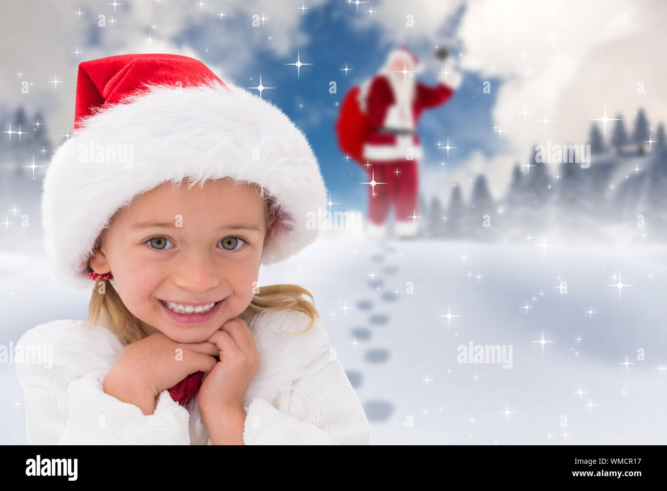 Cute little girl wearing santa hat contre le ciel bleu avec des nuages blancs Banque D'Images