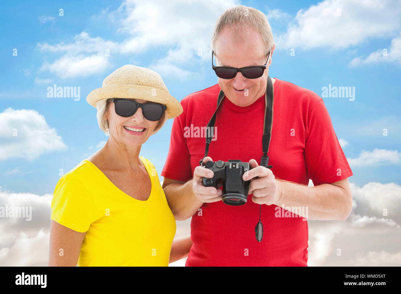 Mature Woman wearing sunglasses against cloudy sky Banque D'Images