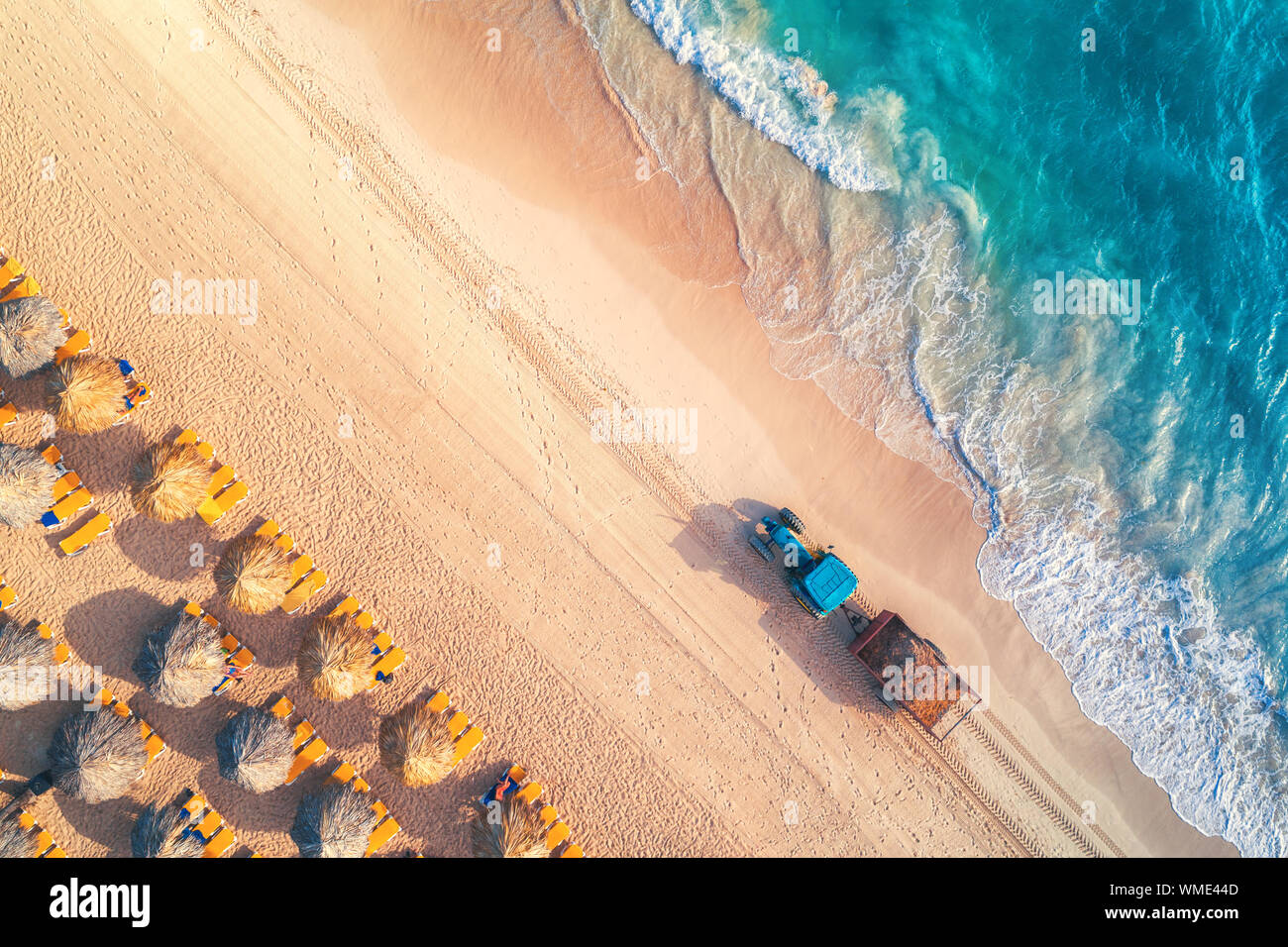 Vue de dessus de l'antenne sur la plage. Parapluies, le sable et les vagues de la mer Banque D'Images