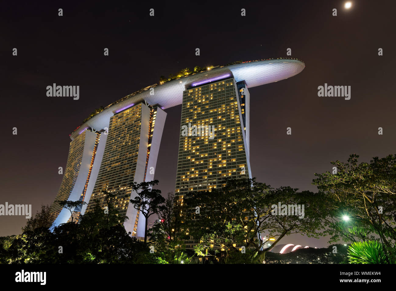 Paysage dans la nuit - Singapour et jardins au bord de la baie, lumières colorées, de l'eau et l'hôtel en forme de voile. Banque D'Images