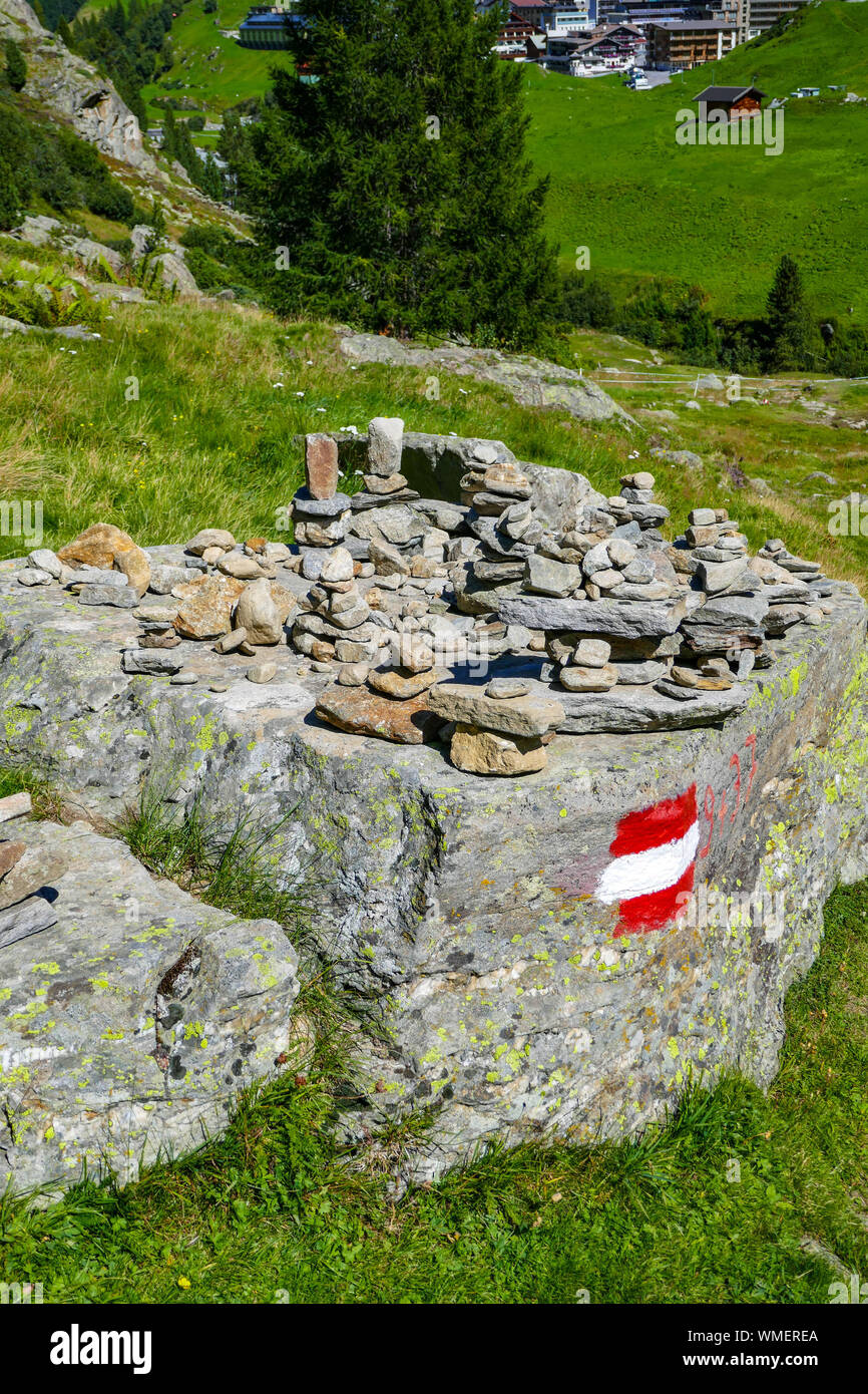 Tas de pierres et waymarker sur de la roche, le vert des montagnes et le bleu journée ensoleillée à Obergurgl, vallée de l'Ötztal, Autriche, Banque D'Images