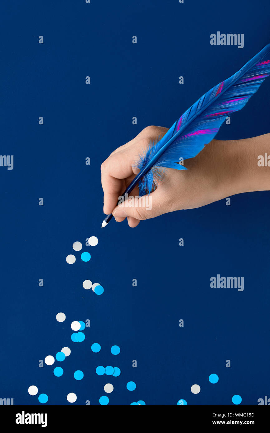 Noël ou Nouvel An concept créatif, dessin à la main à partir de flocons de papier de quill blue feather sur fond de papier bleu foncé Banque D'Images