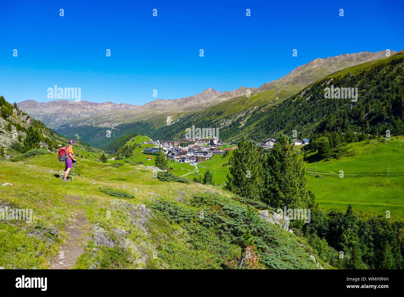 Female hiker dans le vert des montagnes et le bleu journée ensoleillée à Obergurgl, vallée de l'Ötztal, Autriche, Banque D'Images