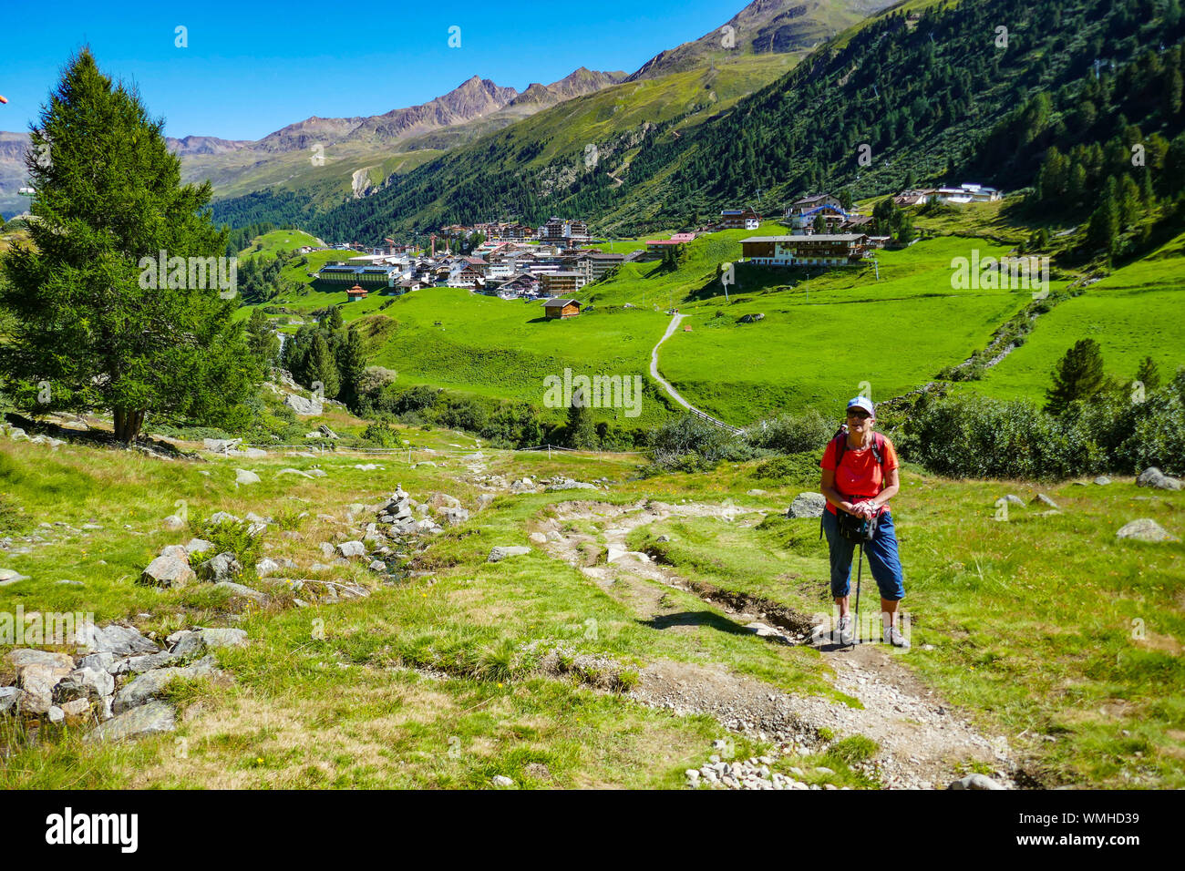 Female hiker dans le vert des montagnes et le bleu journée ensoleillée à Obergurgl, vallée de l'Ötztal, Autriche, Banque D'Images