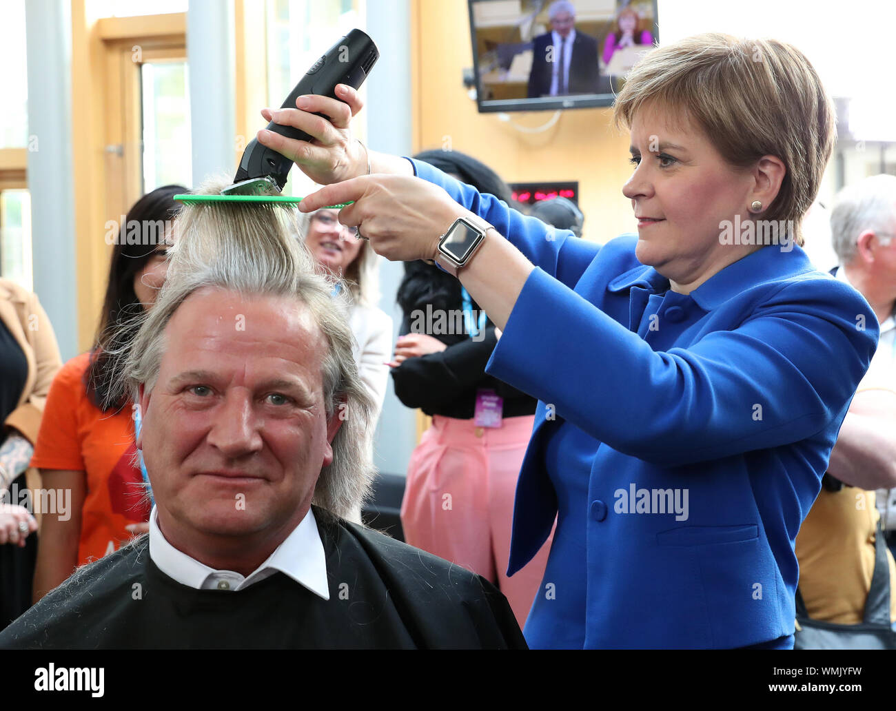 Premier ministre Nicola Sturgeon coupe les cheveux de David Torrance MSP augmentant de 1 000 £ pour l'organisme de bienfaisance Maggie's Centre de Kirkcaldy au parlement écossais à Édimbourg. Banque D'Images