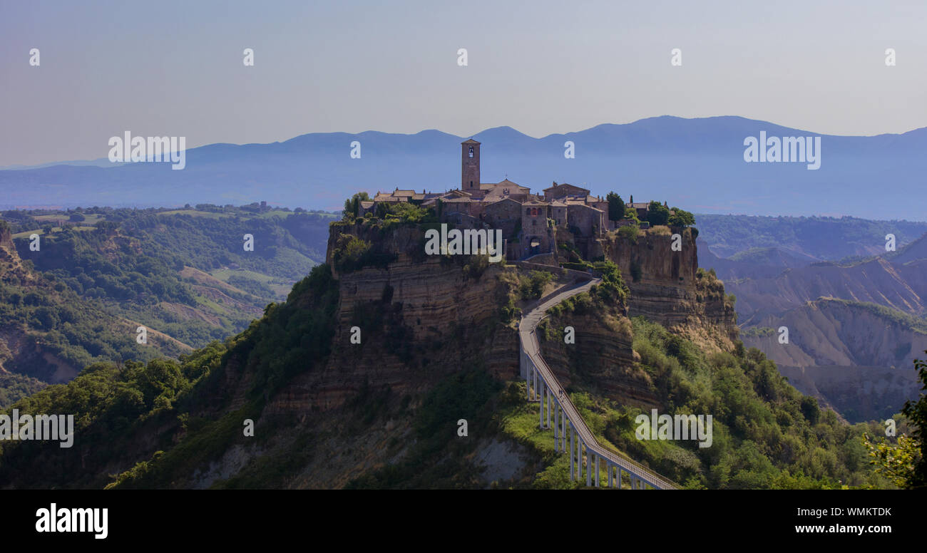 Capture la lumière tôt le matin la ville italienne de Bagnoregio, Viterbo Province. Perché sur son piton de tuf, bleu et les montagnes brumeuses peut être vu derrière Banque D'Images