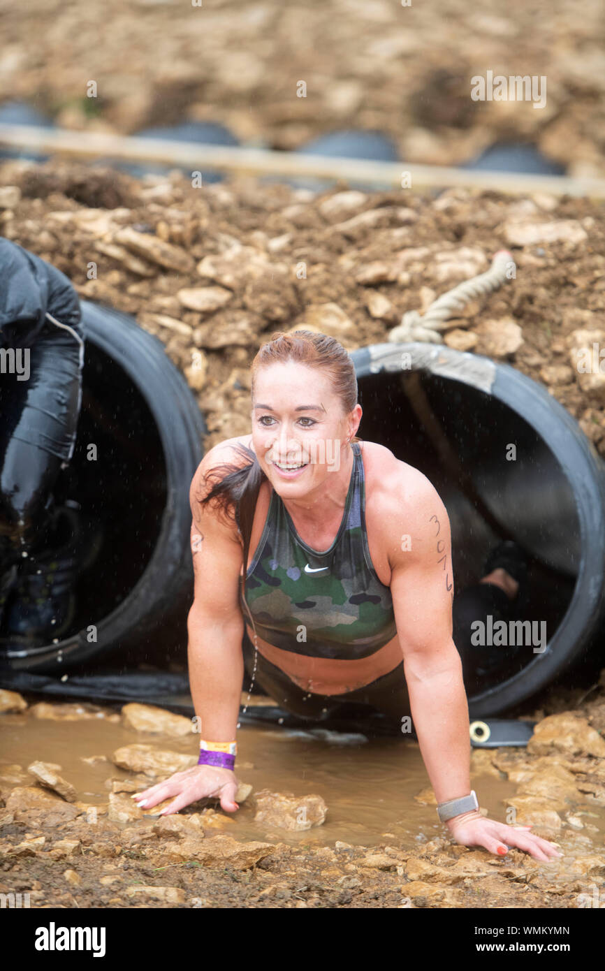 Un participant négocie le "baiser de boue' obstacle à la dure épreuve d'endurance en Badminton Mudder Park, Gloucestershire UK Banque D'Images