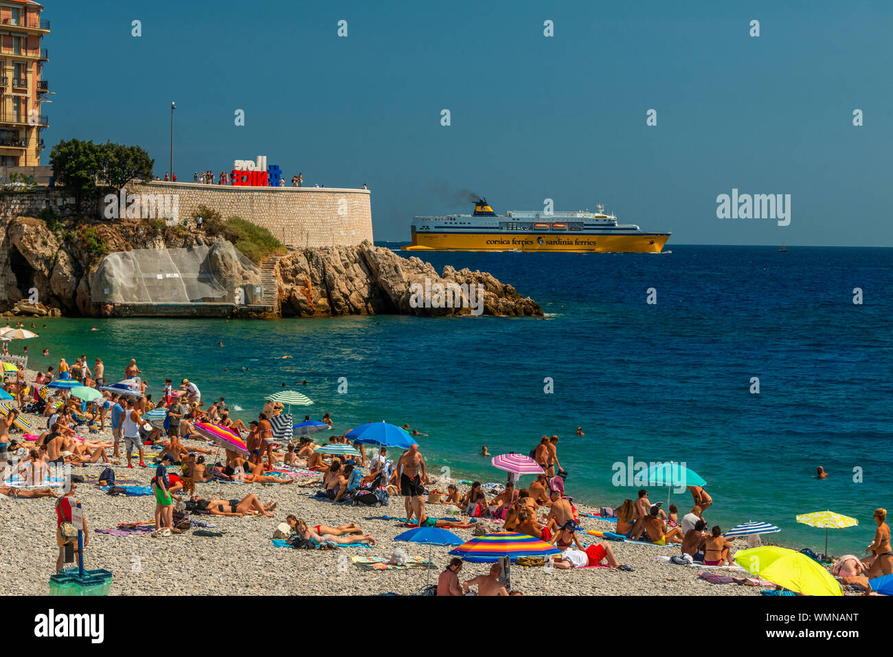 Scène de plage typique avec le ferry corse à Nice, dans la Côte d'Azur région du sud de la France Banque D'Images