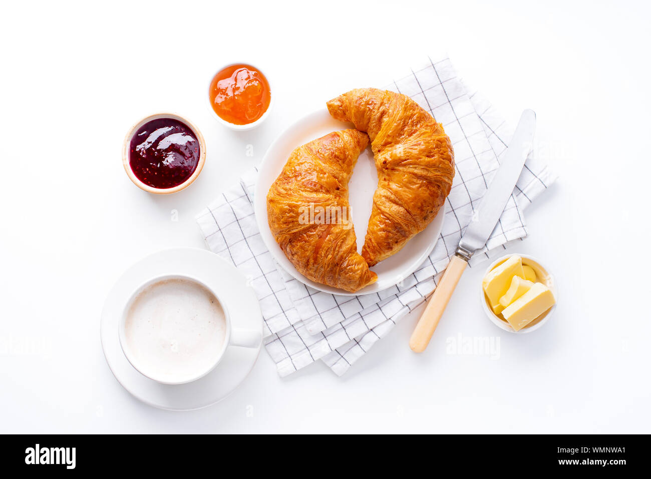 Vue d'en haut flatlay avec croissants frais servis avec des confitures, beurre et café. Concept de repas du matin. Fond blanc Banque D'Images