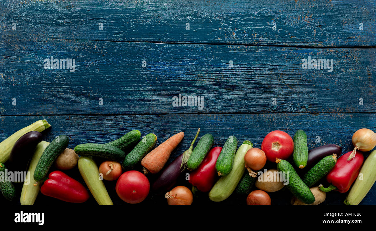 Chasse d'automne. Légumes - tomates et concombres, carottes et chou-fleur, courgettes et aubergines, oignons et pommes de terre sur un vieux fond de bois. Banque D'Images