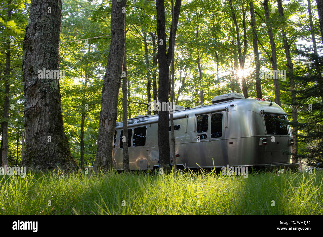 Remorque d'un ruisseau sur un camping entouré de bois avec une rafale solaire (pas de logo, logo enlevé), RVing, caravaning, Camping camping-cars, parking pour véhicules de camping Banque D'Images