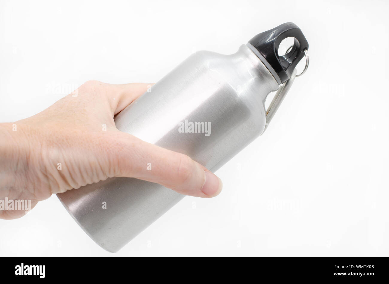 Femme main tenant une bouteille d'eau réutilisable sur un fond blanc. Banque D'Images