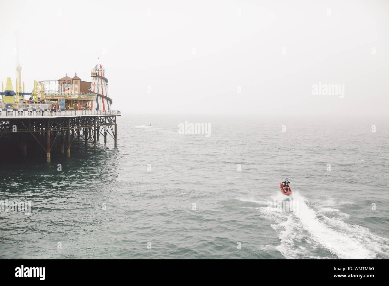 Vue arrière de l'homme saute-moutons sur la mer par la jetée de Brighton Banque D'Images