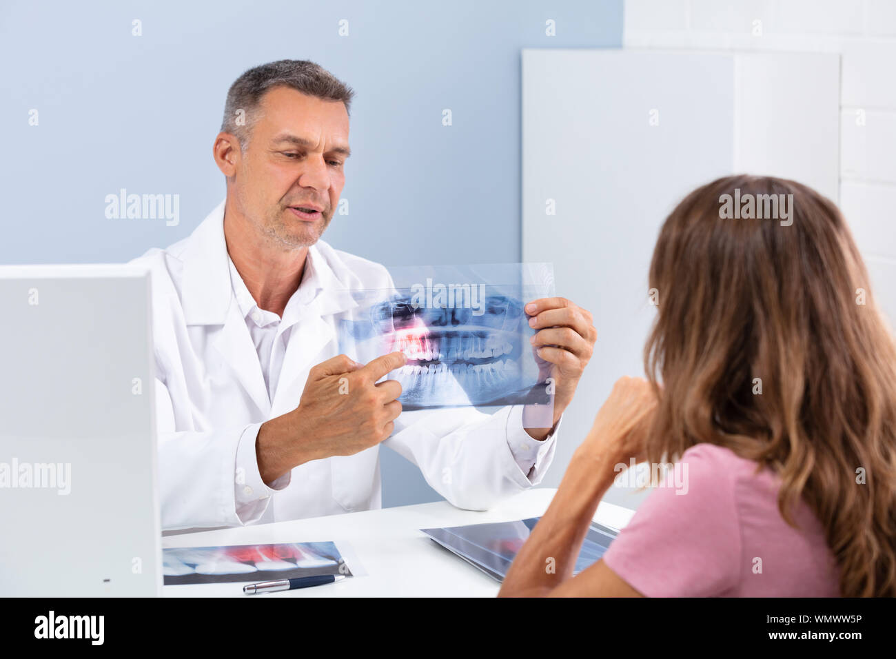 Médecin mature montrant Dental X-ray to Patient In Hospital Banque D'Images