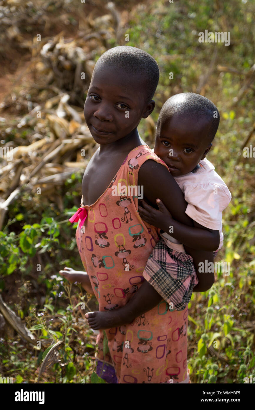 Un enfant au Malawi porte sa sœur sur son dos. Banque D'Images