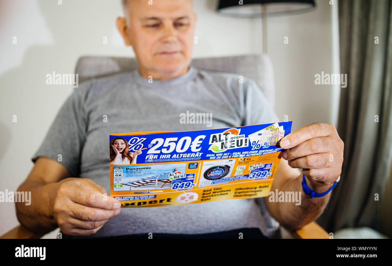 Paris, France - 22 mai 2019 : Senior man holding grave publicité flyer avec sur la couverture de multiples produits ménagers offerts par Oehler Expert - 4k de téléviseurs , machines à laver Banque D'Images
