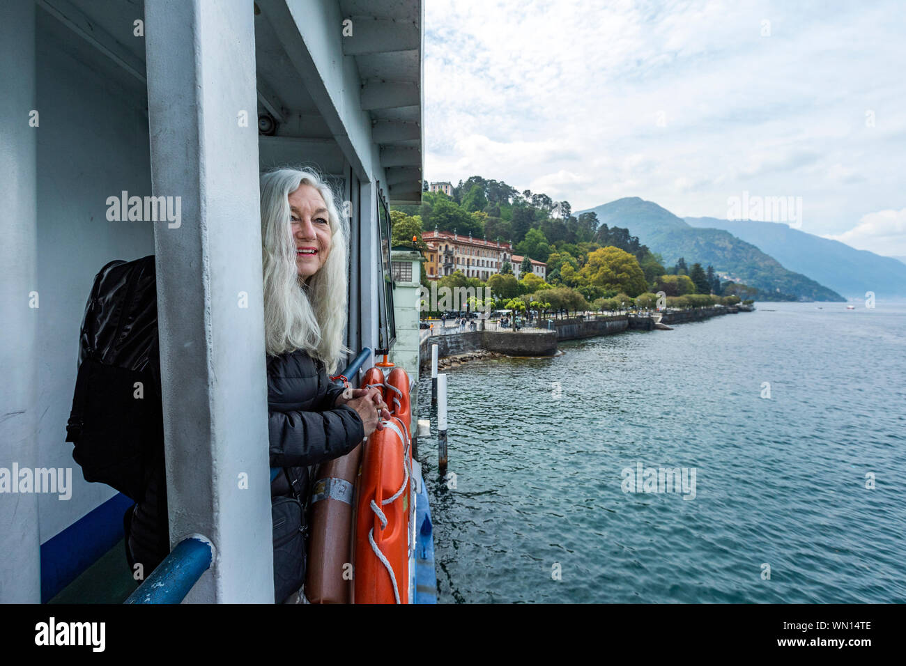 Young woman smiling on ferry sur le lac de Côme, Italie Banque D'Images Young woman smiling on ferry sur le lac de Côme, Italie Banque D'Images