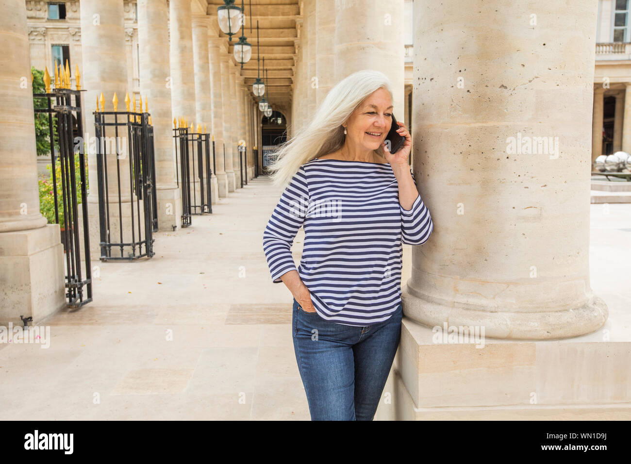 Woman on phone par colonnes du Palais-Royal à Paris, France Banque D'Images