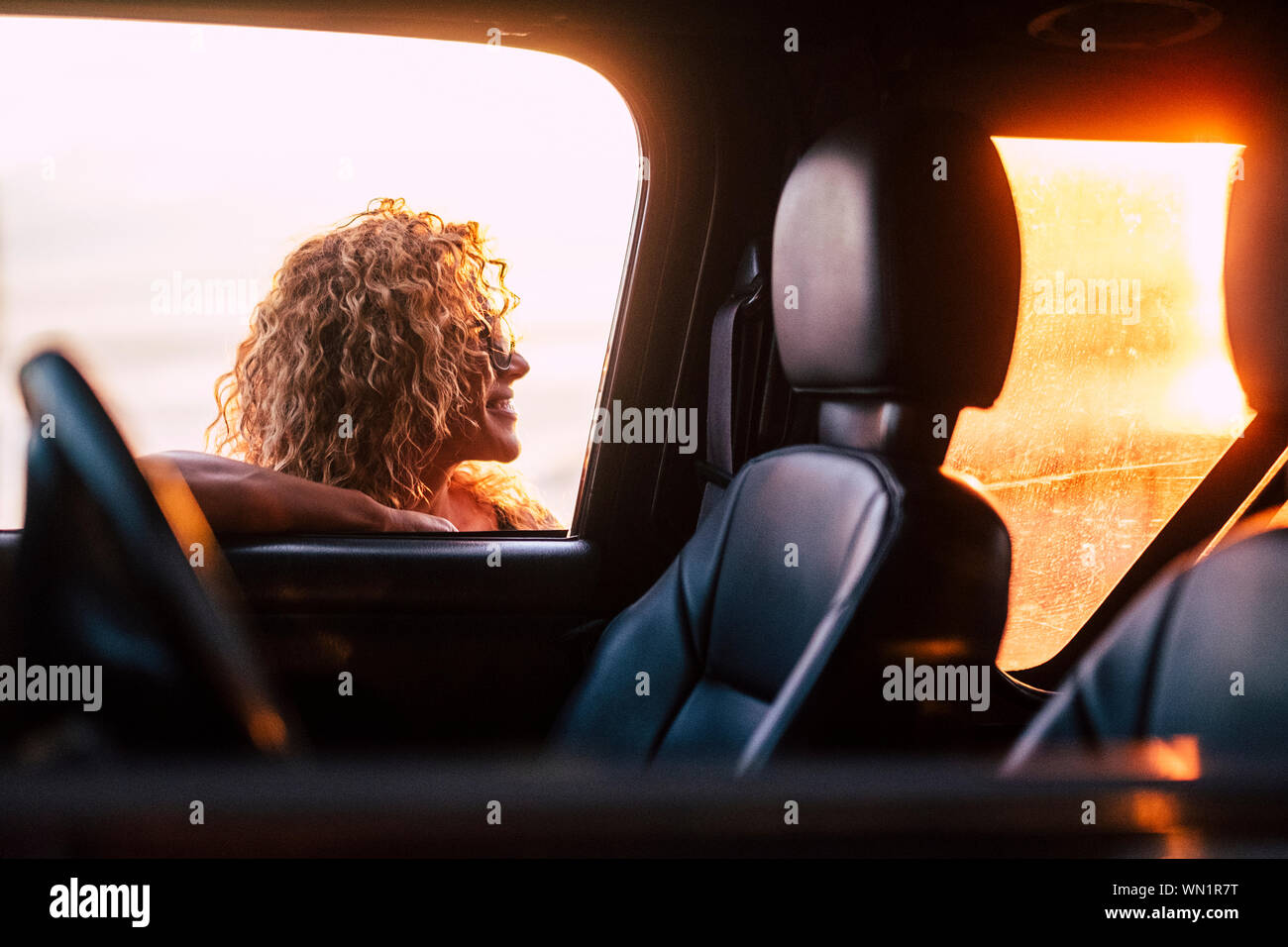 Smiling woman leaning on car window Banque D'Images