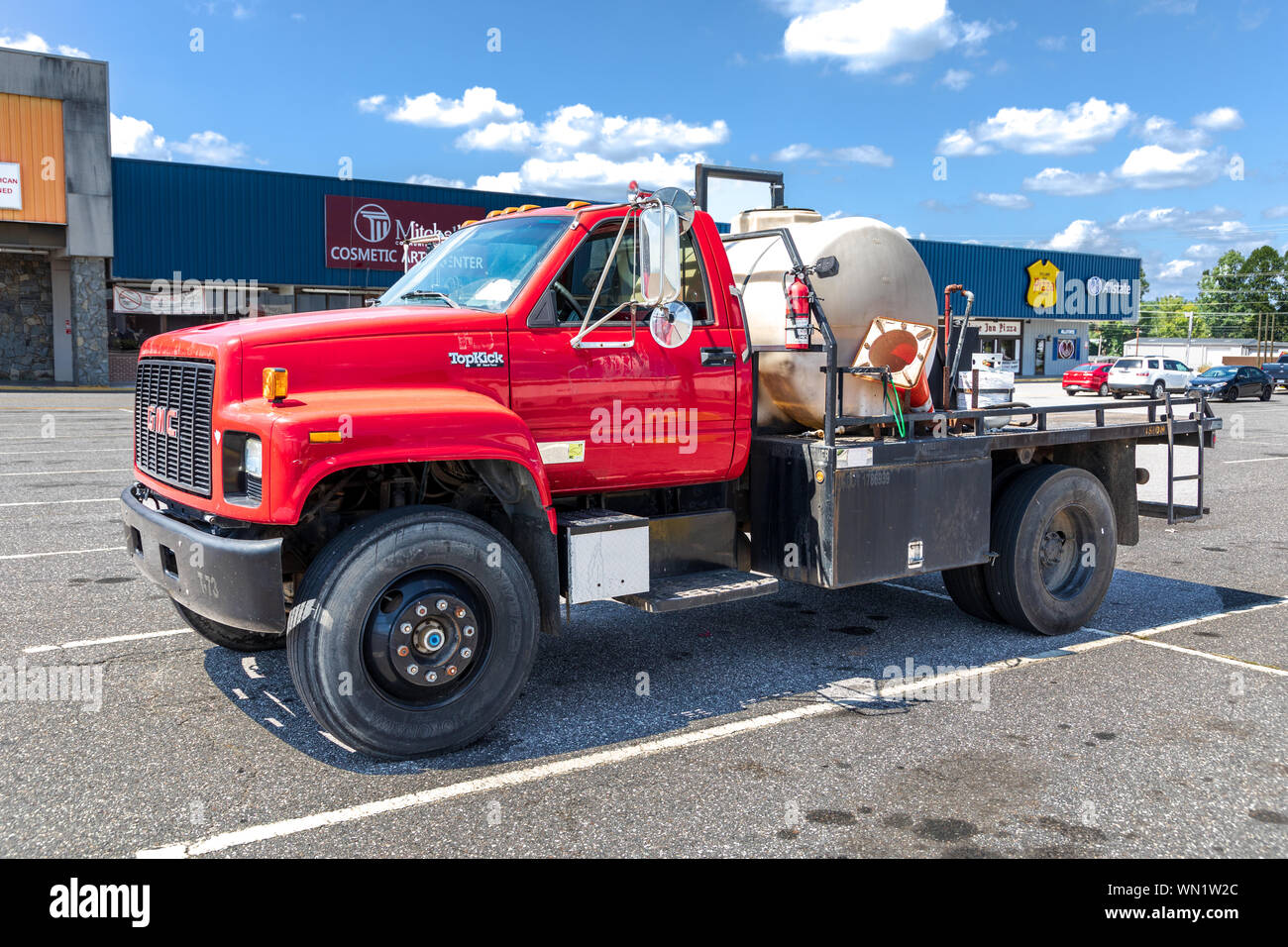 STATESVILLE, NC, USA-1 septembre 2019 : un rouge lumineux, pick-up GMC camion de travail à plat, avec un réservoir de stockage de liquides sur le lit. Banque D'Images