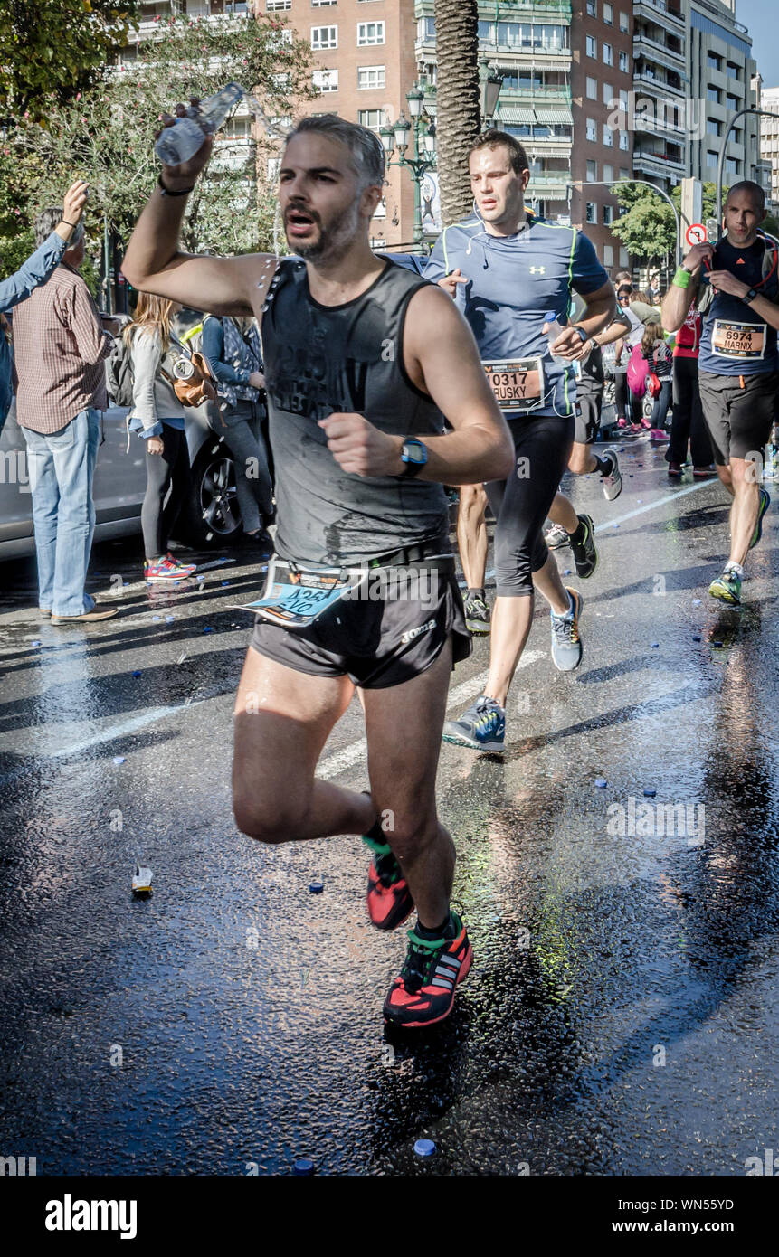 Runner homme eau potable pendant la marathon de Valence en Espagne le 16 novembre 2014 Banque D'Images