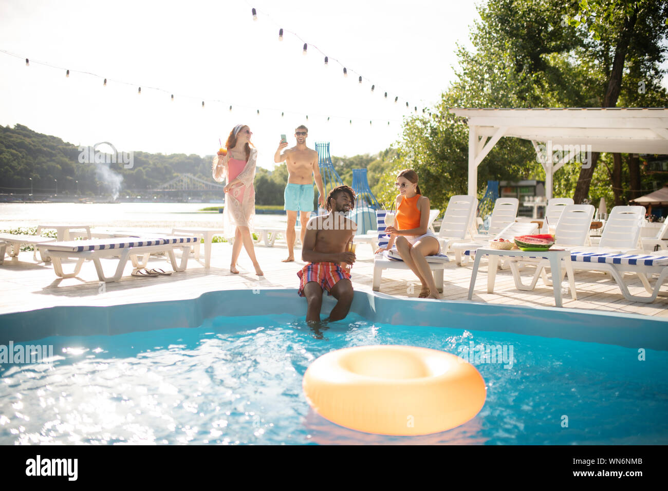 Deux couples ayant amazing pool party sur chaude journée d'été Banque D'Images