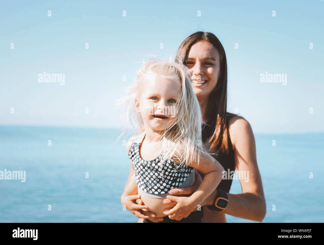 Les jeunes fit woman maman avec peu cute girl l'exercice sur la plage ensemble, le mode de vie sain Banque D'Images