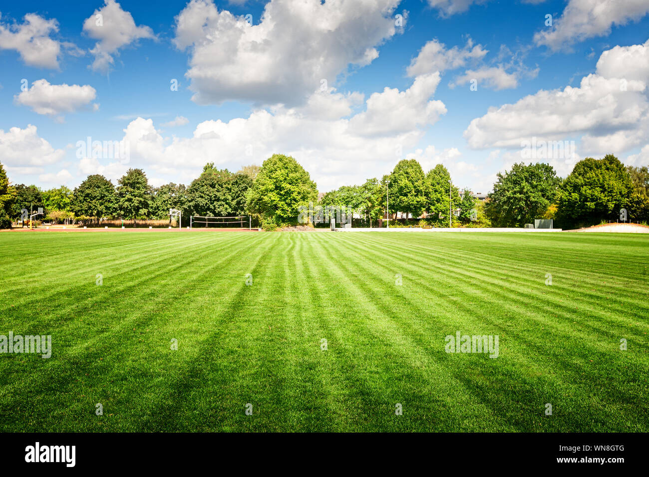 Terrain de football avec de l'herbe verte, le stade et l'aire de stationnement en été, meadow et paysage blue cloudy sky Banque D'Images