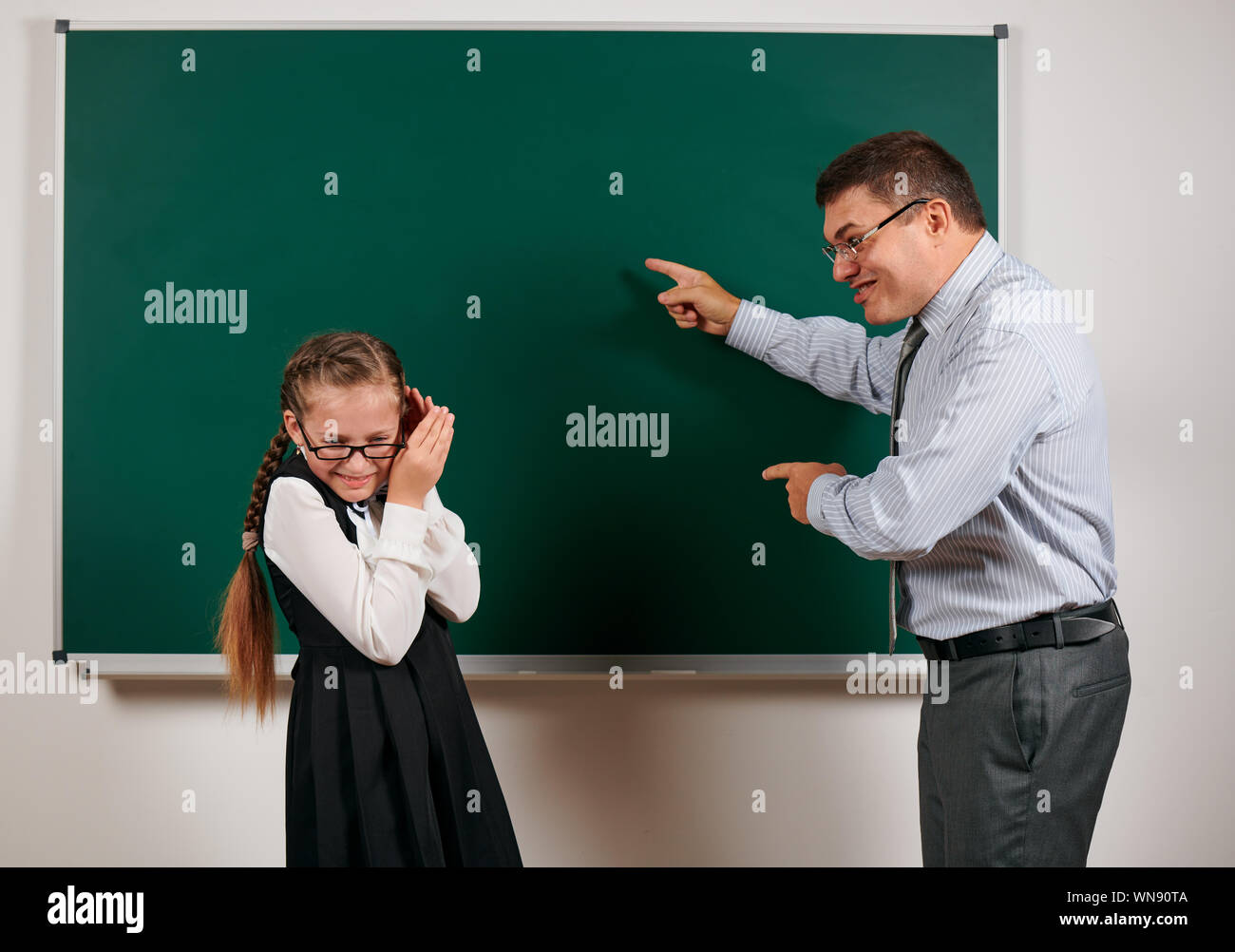 enseignant-en-col-re-crier-pour-lyc-enne-posing-at-blackboard