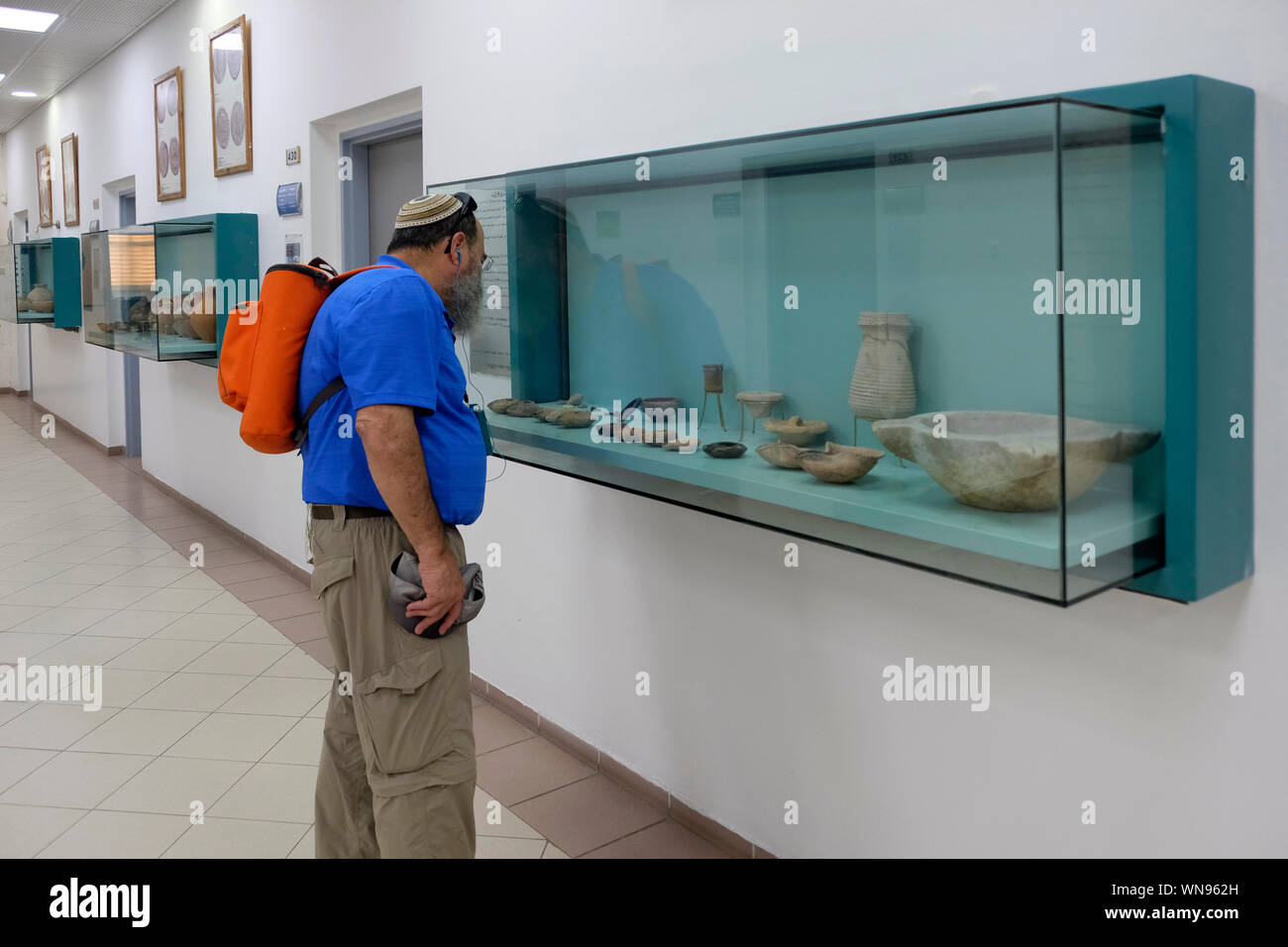 Un homme juif religieux à des objets archéologiques exhumés à l'occasion de fouilles qui raconte l'histoire de Baqa al-Gharbiyye affichée à un couloir intérieur Al-Qasemi Academic College of Education fondée en 1989 comme un collège pour la charia et les études islamiques à la ville arabe de Baqa al-Gharbiya ou Baqa al-Gharbiyye en Israël Banque D'Images