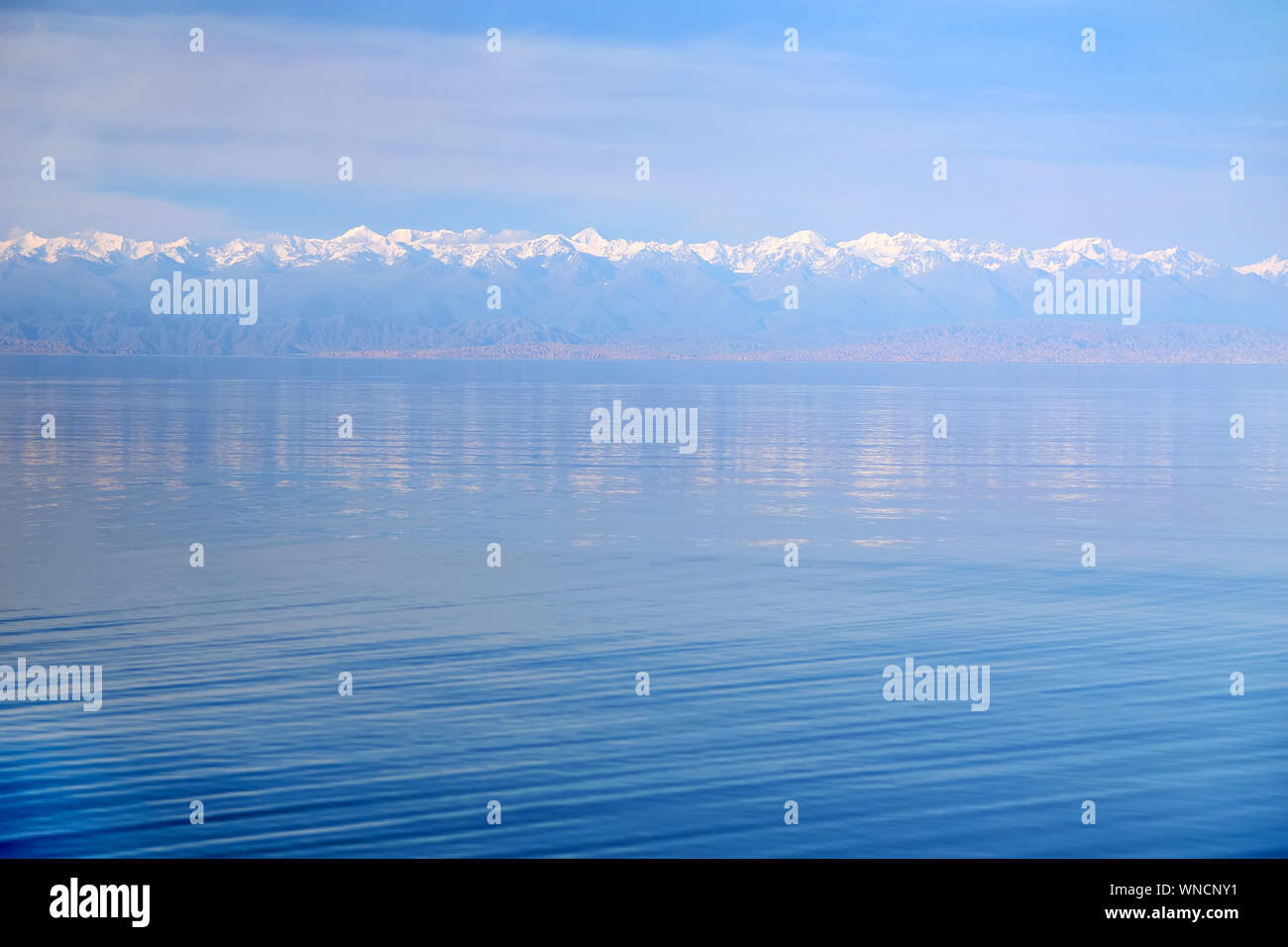 La surface bleue du lac et montagnes enneigées à l'horizon . Banque D'Images