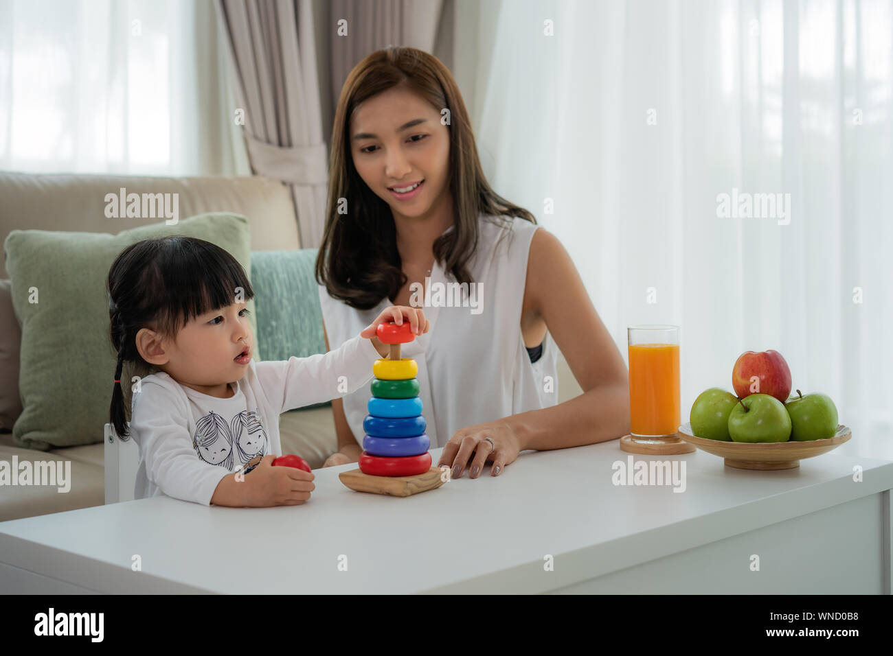 Asian girl avec mère jouer avec bloc en bois coloré à la maison des jouets de développement. Banque D'Images