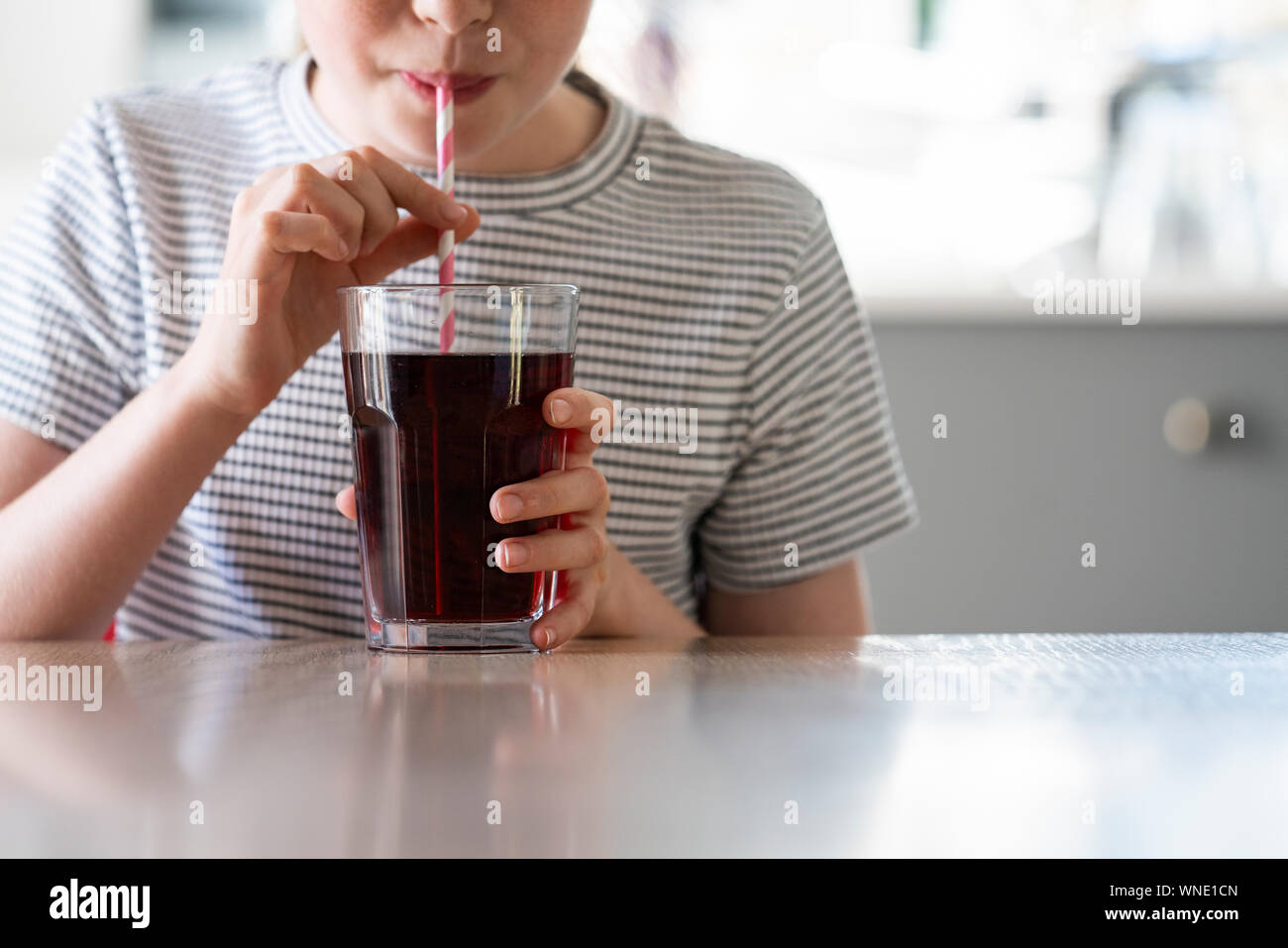 Close Up of Girl Drinking Soda pétillant sucré avec de la paille de verre Banque D'Images