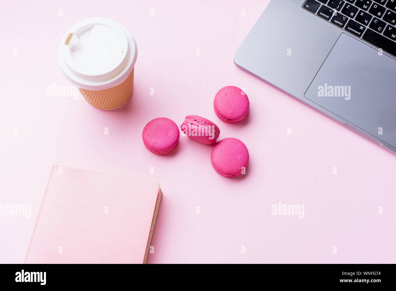 Flatlay avec coffre, café et macarons sur fond rose. Vue de dessus, copiez l'espace. Concept de poste de travail. Banque D'Images