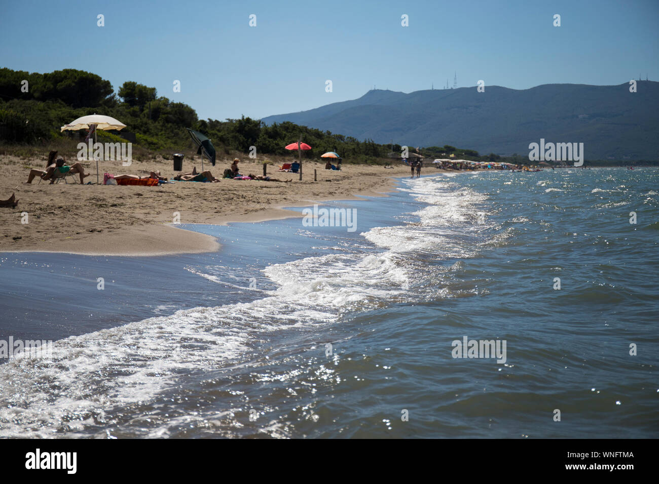 Journée d'été à la belle plage de Giannella à Orbetello, avec le Mont Argentario en arrière-plan et les gens sur la plage. La toscane, italie. Banque D'Images