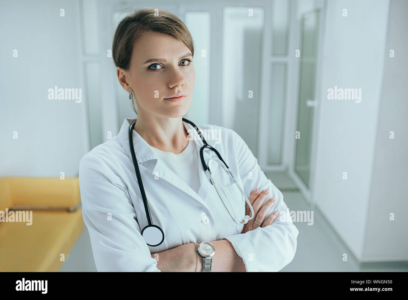 Middle aged female doctor standing in hospital corridor with stethoscope Banque D'Images