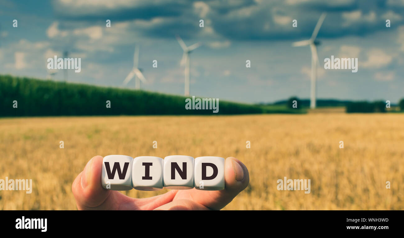 Formulaire dés le mot 'Vent' en face d'un parc éolien. Banque D'Images
