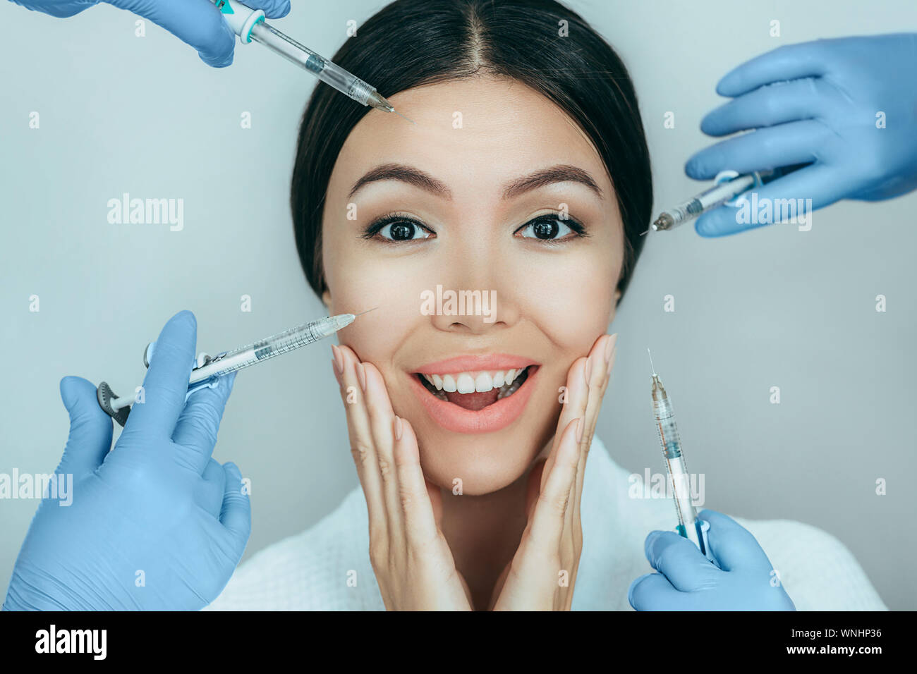Femme avec le choc face à la caméra au près de son visage de seringue avec injections de beauté. Publicité incroyable injections anti de vieillissement Banque D'Images