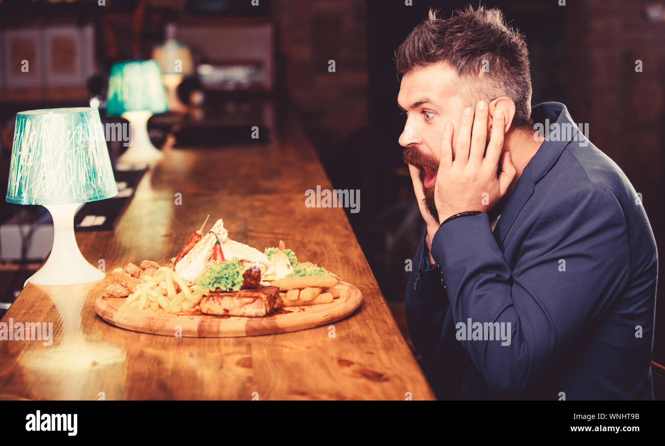 Des calories. Vous pourrez vous détendre après une dure journée de travail. Woman costume formel s'asseoir à comptoir bar. L'homme a reçu de pommes de terre frites repas avec viande et poisson, lavash. Il méritent de délicieux repas. Profitez de repas. Banque D'Images